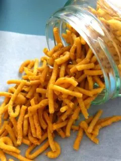 Namkeen Sev in a jar and spread out on a parchment paper