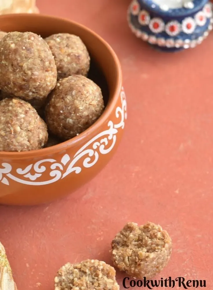 Oats Energy Bites in a brown bowl. seen in background are some diyas. A closer look of a split ladoo