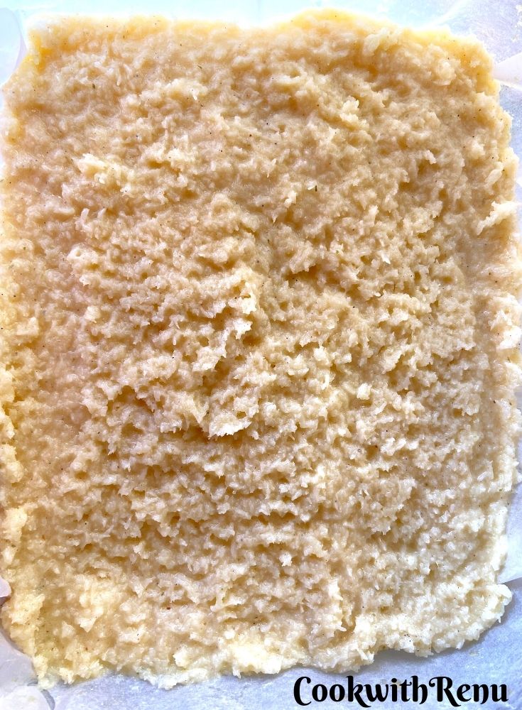 Setting the cardamom flavoured coconut in a tray