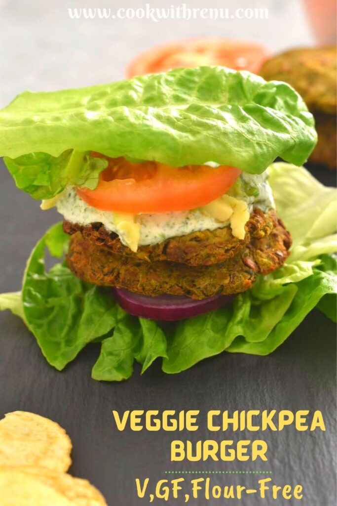 Vegan chickpea patties assembled in lettuce wraps along with tomato, onion, avocado and nasturtium dip