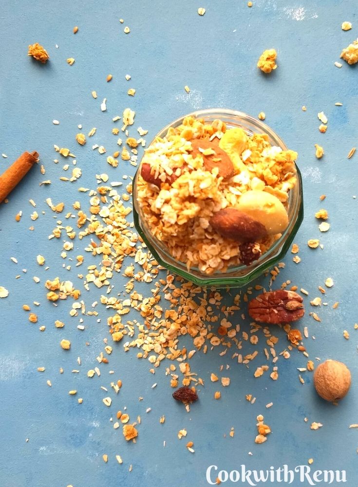 Top view of granola in a glass jar and oats spread on a serving board