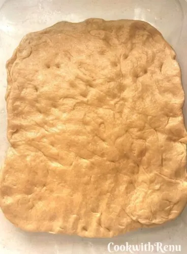 Focaccia patted on a baking sheet