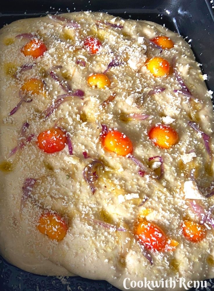 Toppings tomato, cheese and onion drizzled on focaccia bread