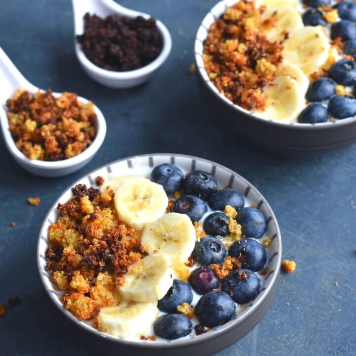 Quinoa crispies served in yogurt bowl along with banana and blueberries