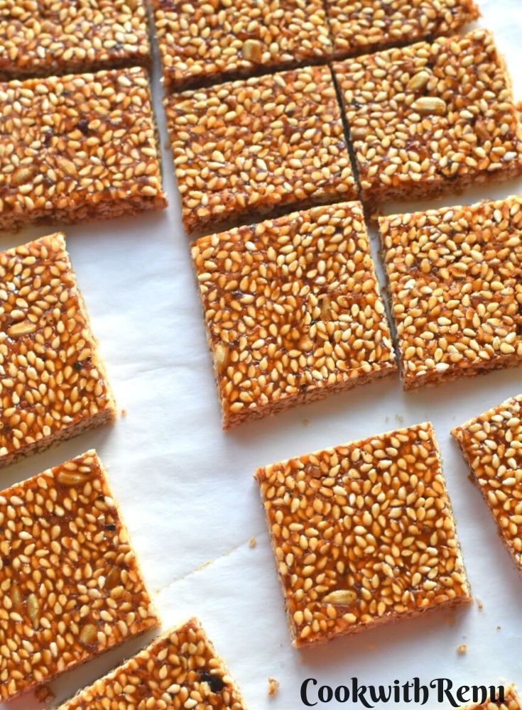 Cut square pieces of til gul chikki laid on a paper