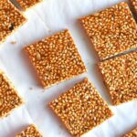Cut square pieces of til chikki laid on a paper