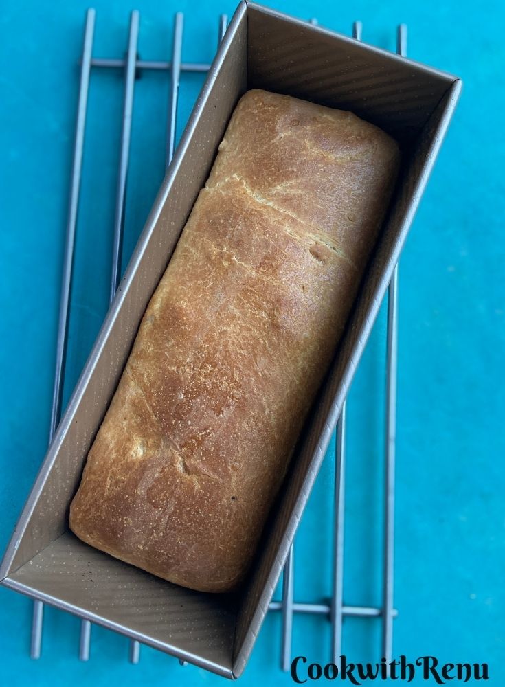 Baked bread just out of the oven and cooling on a wire rack