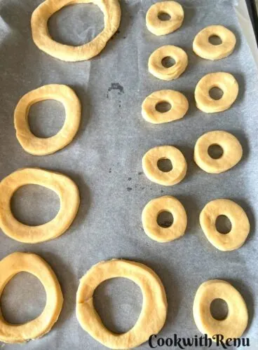 Donuts being shaped and arranged on a parchment paper