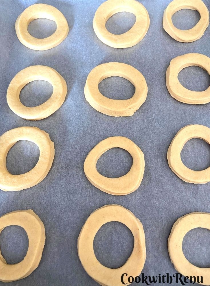 Donuts being shaped and arranged on a parchment paper