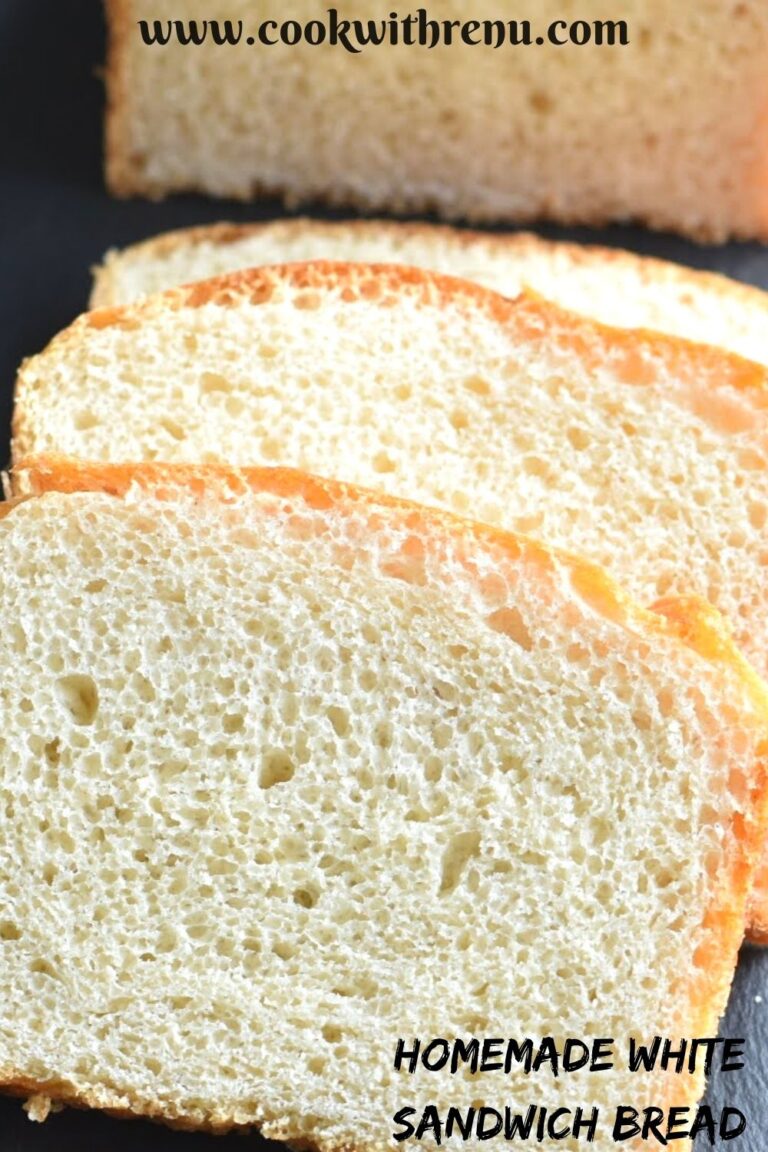 Slices of white bread arranged on a black cheese board with half cut bread seen in the background