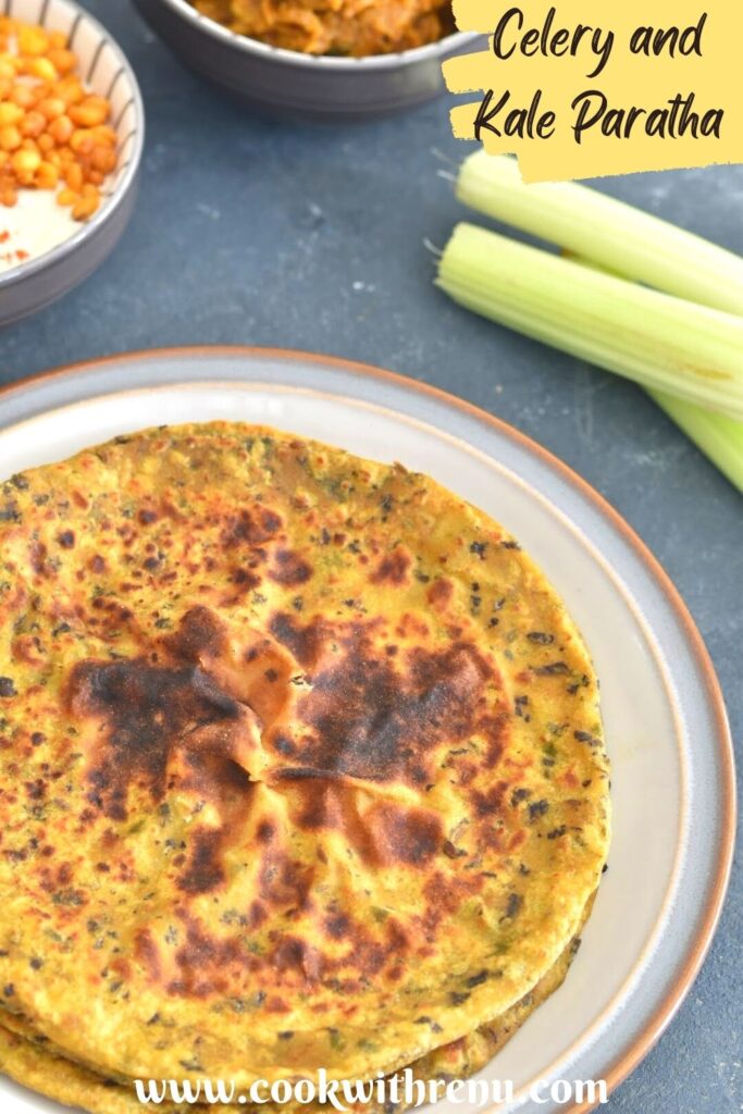 Stack of Celery and Kale Paratha served on a white plate, with few celery stalks on the side. Seen along side is boondi raita and baingan bharta