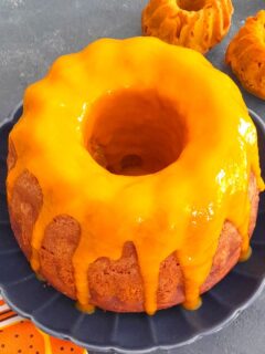 Easy Eggless Mango Bundt cake with a generous drizzle of mango pulp and seen in the background are 2 more small Bundt muffins