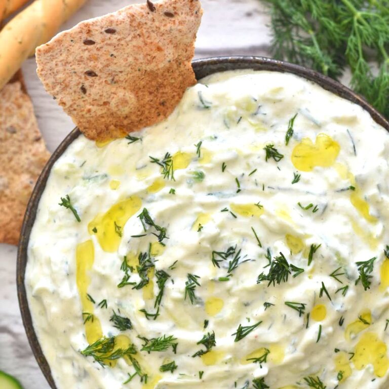 Close up look of Cucumber Dill Tzatziki served in a black bowl along with some baked bread