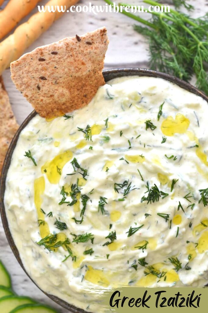 Cucumber Dill Tzatziki served in a black bowl along with some baked bread