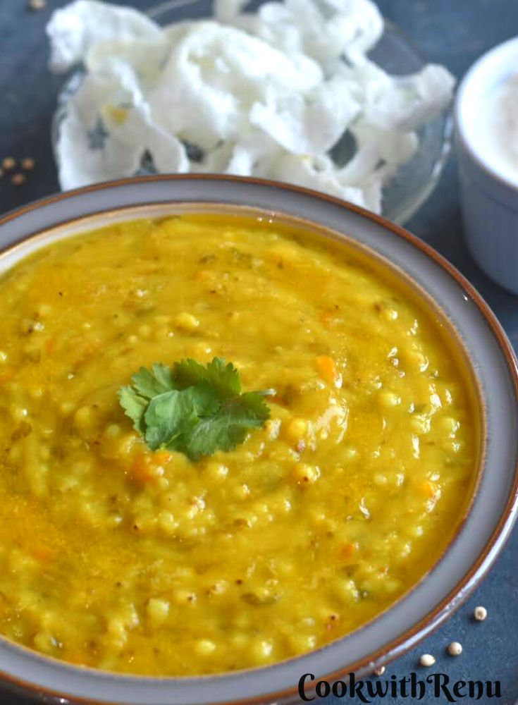 Jowar Moong Dal Khichdi served in a grey bowl, with curd and some papad