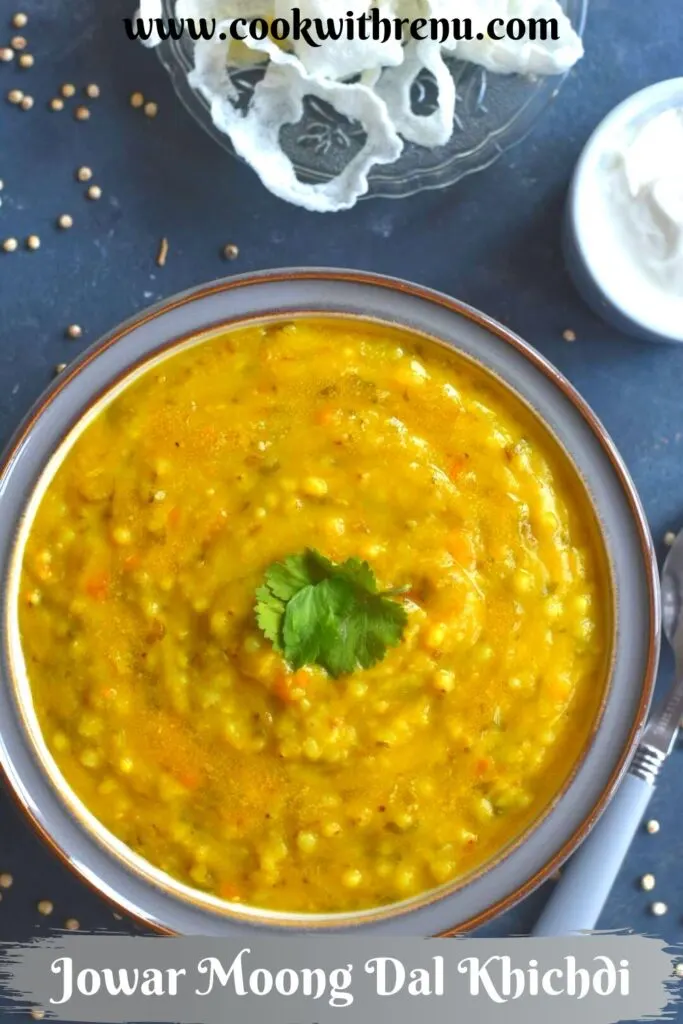 Jowar Moong Dal Khichd served in a grey bowl, with curd and some papad