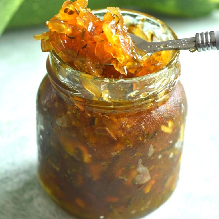 Lemon Ginger Zucchini Marmalade presented in a glass jar, with a close up look of jelly in a spoon