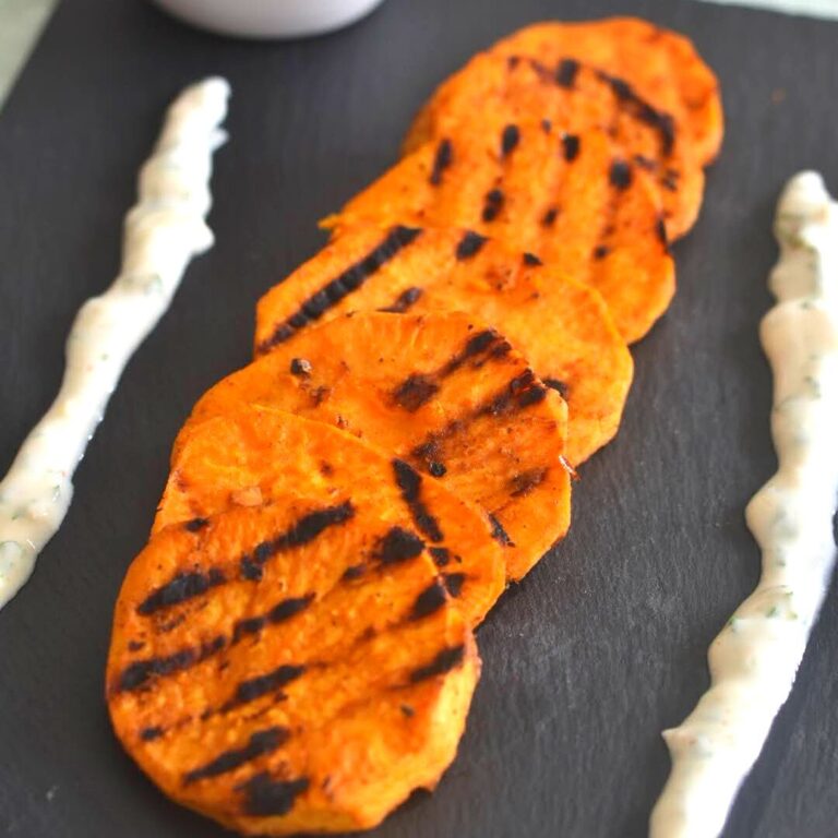 Peri-Peri Grilled Sweet Potato served on a black cheese board along with some yogurt dip