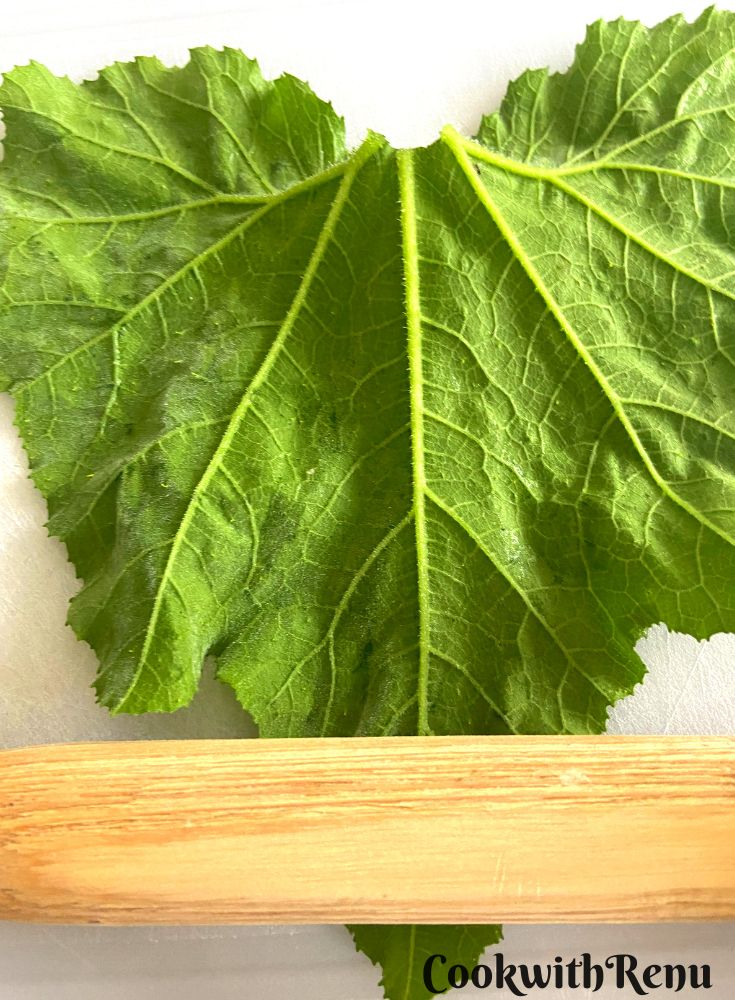 Flattening the leaves with the rolling pin.