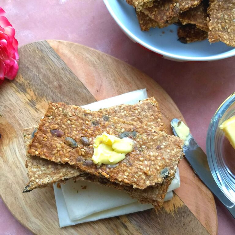 Knäckebröd – Swedish Multi-Seed Crispbread served on a brown board with some butter spread on top