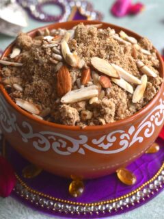 Kuttu aur Dhaniya Panjiri served in a brown bowl. Seen along side are some rose petals and some festive decorations