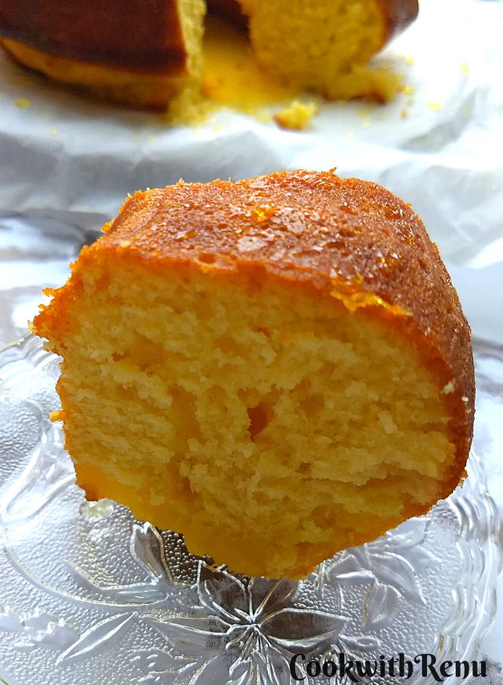 A close up slice of orange yeast bundt cake served on a crystal plate.