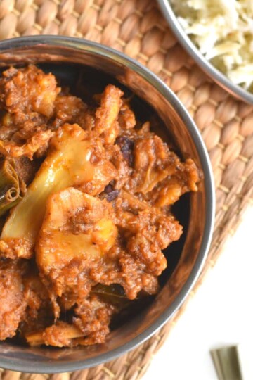 Sri Lankan Raw Jackfruit Curry presented in a steel bowl with some white cooked rice on the side.