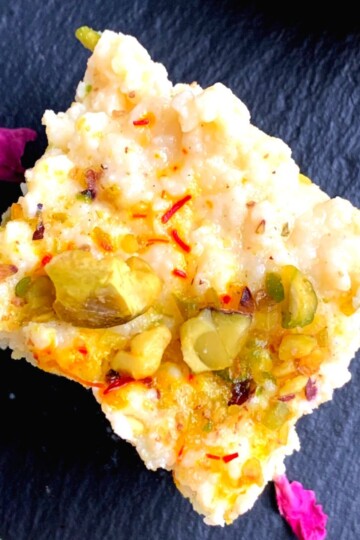 Top View of Kalakand or milk fudge on a black cheese board.