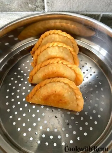 Fried Gujiya on a stainer.