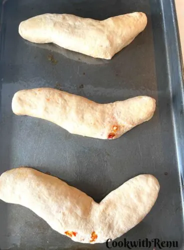 Shaping of Halloween Pizza Bread in the form of snake.