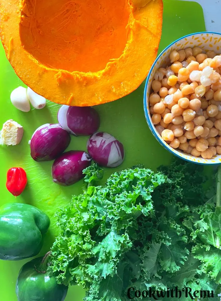 The Ingredients for Pumpkin Chickpea kale curry on a green chopping board.