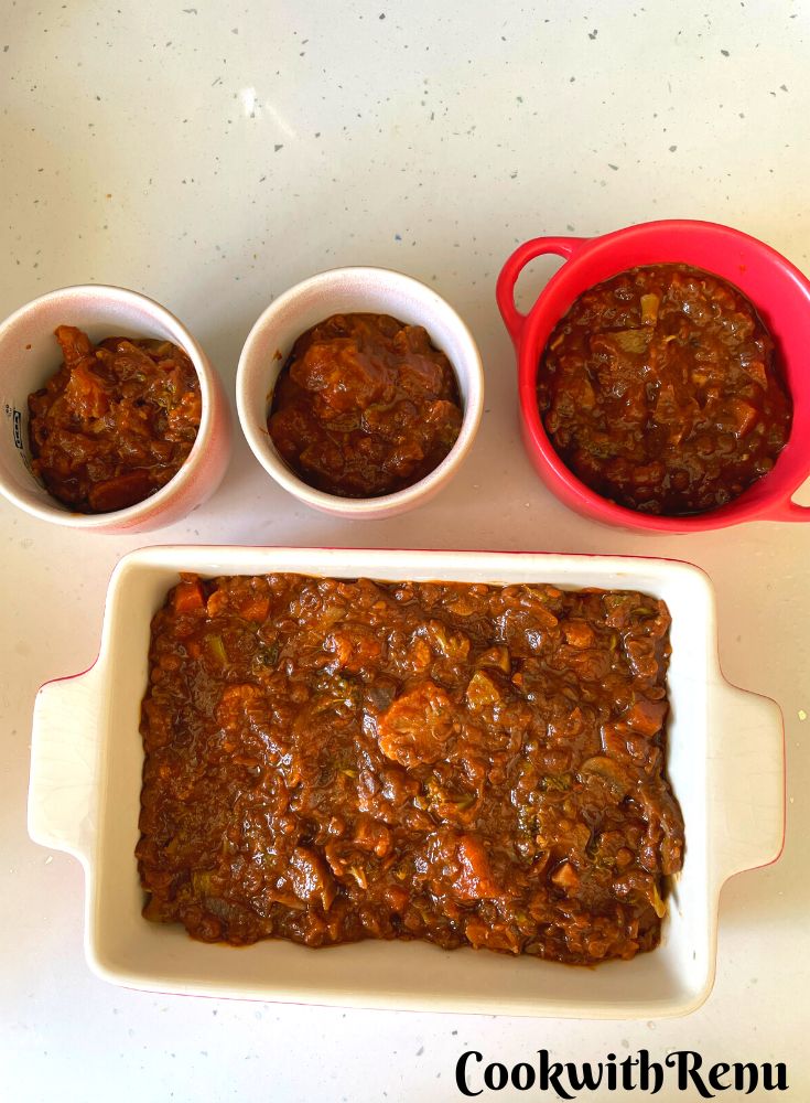 Layering of the curry in the baking tins.