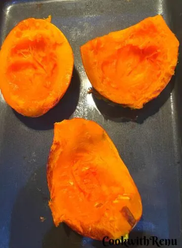 Baked Pumpkin in Oven on a black tray.