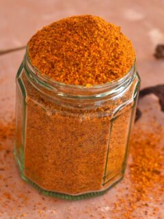 Gun powder in a glass jar with some chilies and some powder lying around