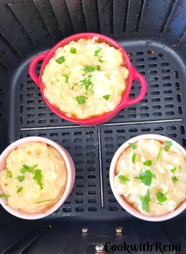 Mini Shepherdless Pie read to be baked in air fryer baked in air fryer in ramekin moulds and seen in an air fryer basket.