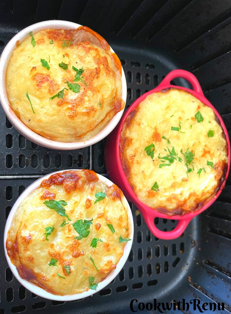 Mini Shepherdless Pie baked in air fryer baked in air fryer in ramekin moulds and seen in an air fryer basket.