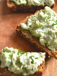Open-Faced Celery Avocado Sandwich served on a brown cheese board with a garnish of chives.
