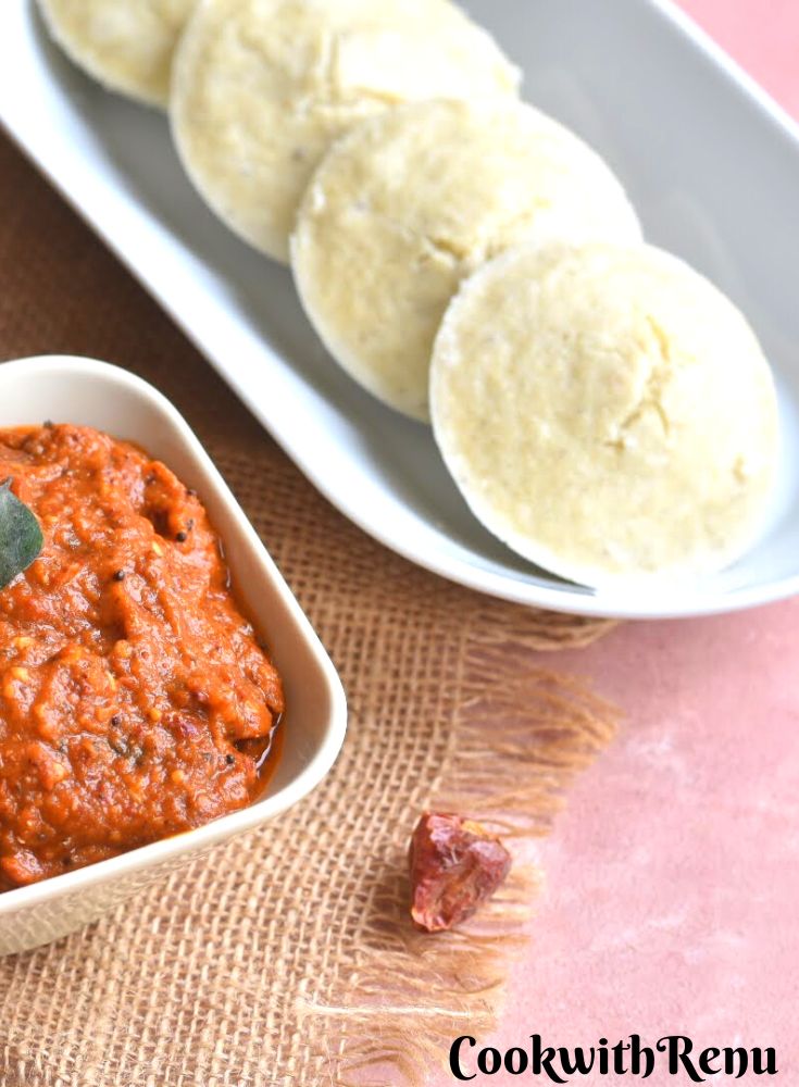 Idli served in a white rectangular plate with Chettinad Spicy Red chili chutney.