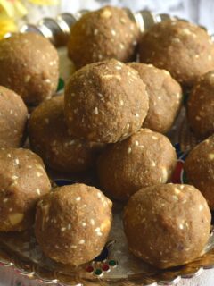 Close up view of Bajra Ladoo served in a golden plate.