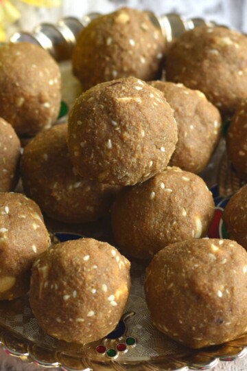 Close up view of Bajra Ladoo served in a golden plate.