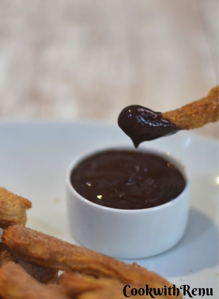Vegan Air Fryer Churros dipped in chocolate sauce.