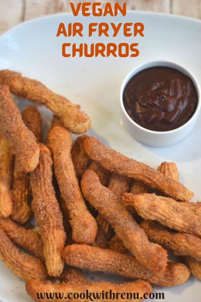 Vegan air fryer churros served on a white plate served with some dipping chocolate sauce.