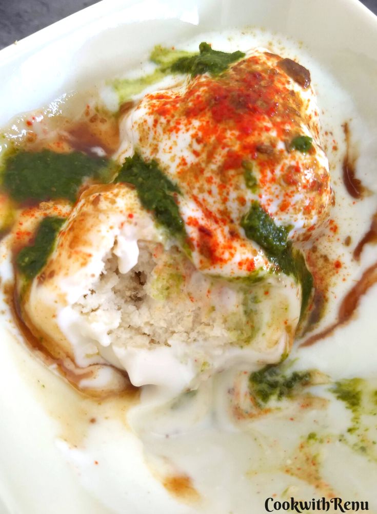 Close up look of texture of dahi bhalla, which is topped up with chutneys.