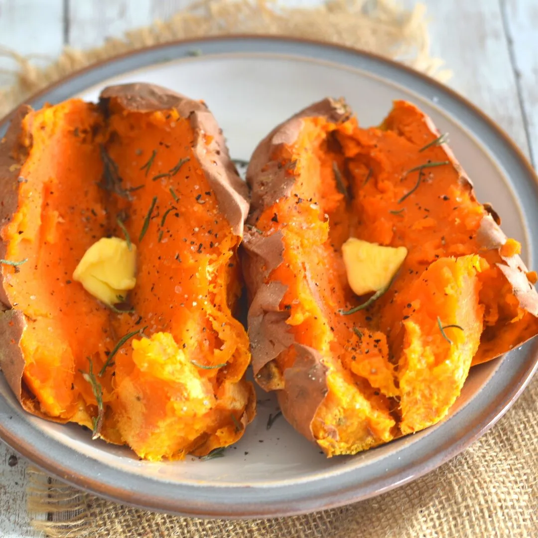 2 Air Fryer Baked Sweet Potato served with a dollop of butter and rosemary, black pepper powder and salt sprinkled on it.