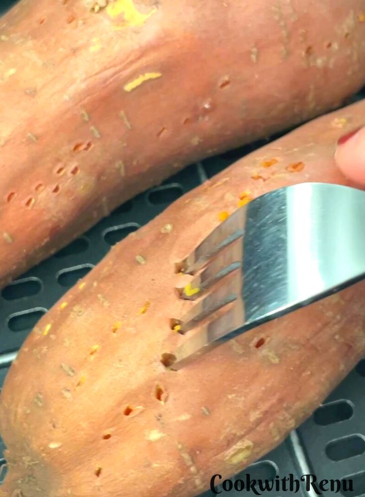 Checking if the potatoes are done by inserting a fork.