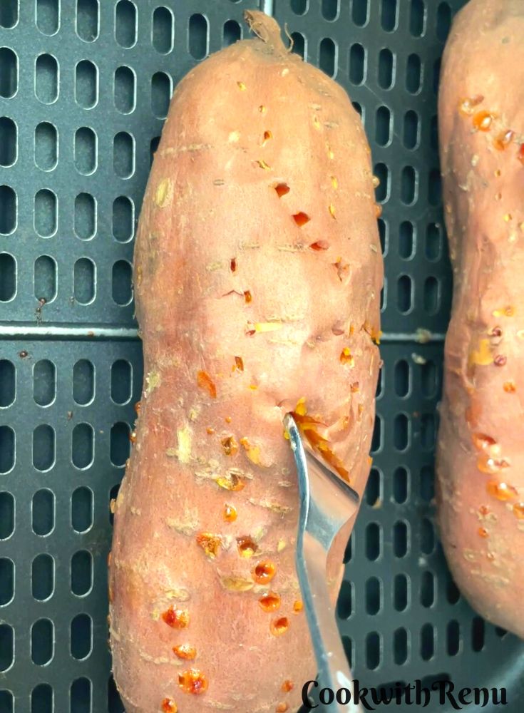 Checking if the potatoes are done by inserting a fork.