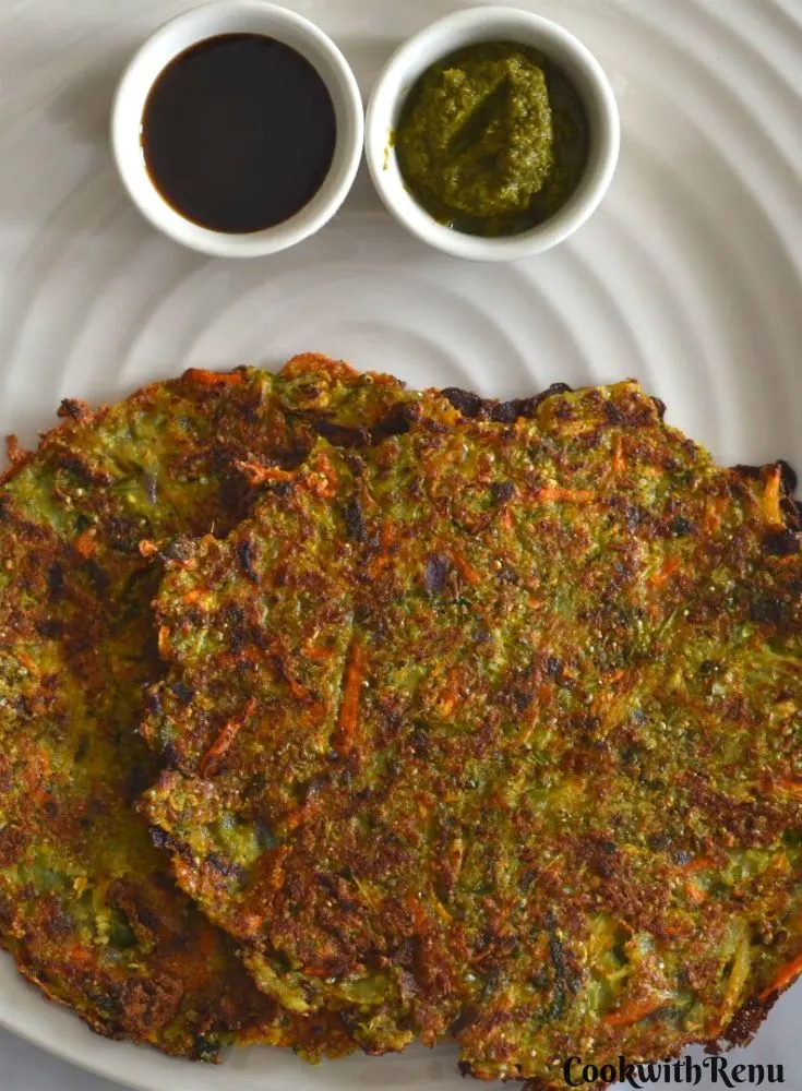 Sprouted Pearl millet savory pancake served in a white plate along with tamarind and coriander chutney.