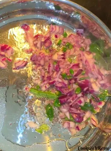 Adding onion and green chili in oil.