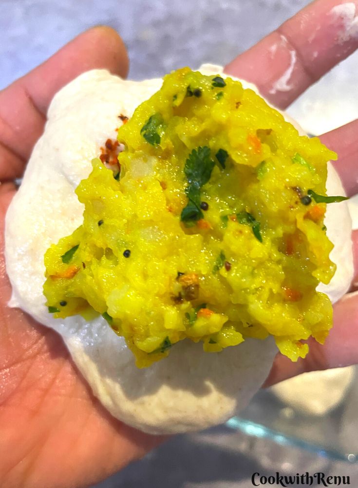 Adding the potato filling in the dough balls.