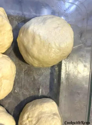 Arranging the stuffed dinner rolls in a tray.